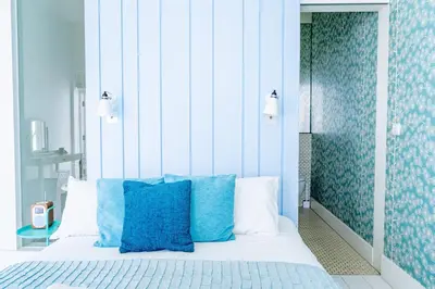 a bedroom with blue and white pillows on a bed at Edinburgh House 4 in Aldeburgh