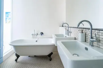a white bathroom with two sinks and a tub at Edinburgh House 4 in Aldeburgh