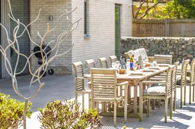 a long wooden table and chairs on a patio at Heath House in Thorpeness