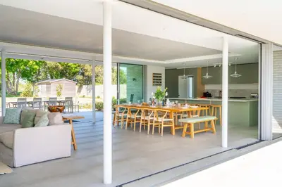 an open kitchen and dining room with sliding glass doors at Heath House in Thorpeness