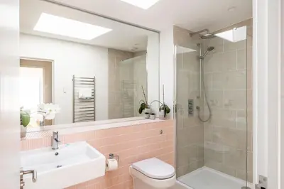 a bathroom with a shower and a toilet and a sink at Heath House in Thorpeness
