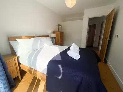 a bedroom with a large bed with towels on it at Modern stylish house in Charming Fen Ditton Village in CBG