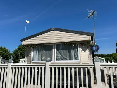 a white house with a white picket fence at Perfect days away - 3 bedroom 1 shower with decking & bedding in Colchester