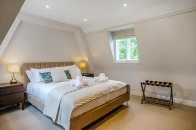 a bedroom with a large bed and a window at Very best location - Luxury boutique apartment by river and historic city centre in Cambridge