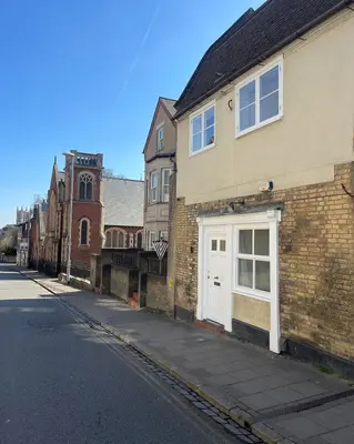 a brick building with a white door on a street at Very best location - Luxury boutique apartment by river and historic city centre in Cambridge