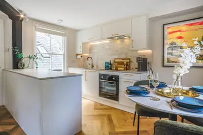 a kitchen with a table with blue plates on it at Very best location - Luxury boutique apartment by river and historic city centre in Cambridge