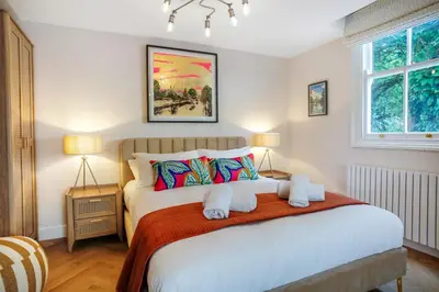 a bedroom with a large bed with two lamps at Very best location - Luxury Studio by river and historic city centre in Cambridge