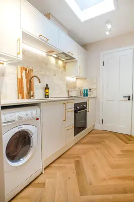 a kitchen with a washing machine and a washer at Very best location - Luxury Studio by river and historic city centre in Cambridge