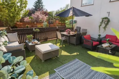 a patio with a table and chairs and an umbrella at Huge 8 Bed Manor House with Hot Tub, Cinema Room, Games Room in Hailsham