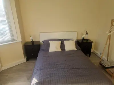 a bedroom with a large bed with two pillows at 1930s conversion two apartment in Harold Wood