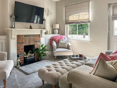 a living room with a couch and a fireplace at Lavender Cottage in Frinton-on-Sea