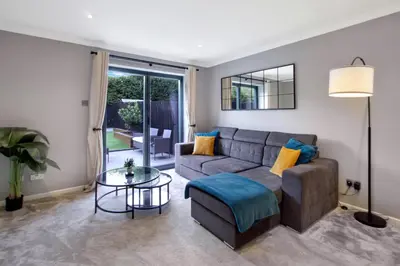 a living room with a couch and a glass table at Spotless Two-Bedroom Home with Garden and Parking in Stevenage