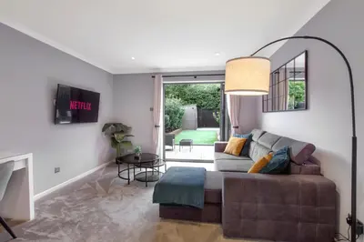 a living room with a couch and a table at Spotless Two-Bedroom Home with Garden and Parking in Stevenage