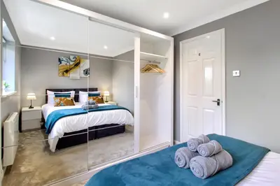 a bedroom with a bed and a glass wall at Spotless Two-Bedroom Home with Garden and Parking in Stevenage