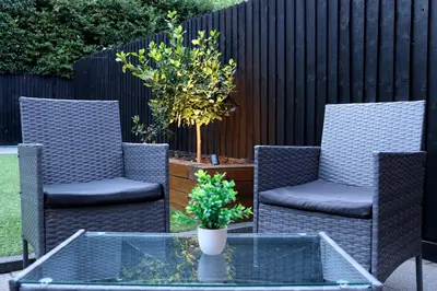 a patio with two chairs and a table with a plant at Spotless Two-Bedroom Home with Garden and Parking in Stevenage