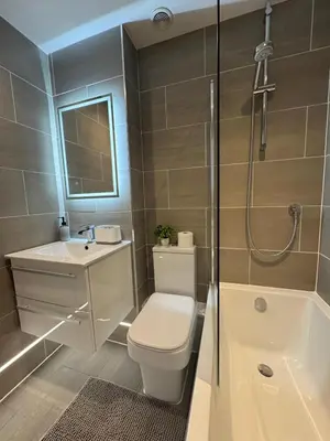 a bathroom with a toilet and a sink and a shower at Spotless Two-Bedroom Home with Garden and Parking in Stevenage