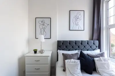 a bedroom with a bed with two framed drawings on the wall at 1 Bed Apartments, 2 Mins to Beach, Sleeps 4 in Southend-on-Sea