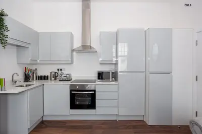a white kitchen with white cabinets and appliances at 1 Bed Apartments, 2 Mins to Beach, Sleeps 4 in Southend-on-Sea