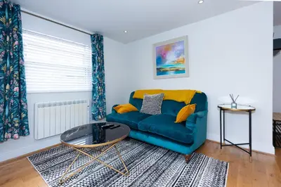 a living room with a blue couch and a table at First Class Flat in Brandon