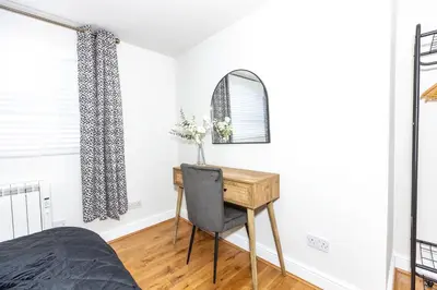 a bedroom with a desk and a mirror at First Class Flat in Brandon