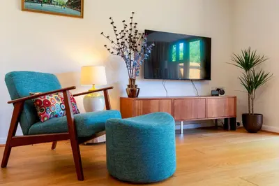 a living room with two chairs and a tv at Stylish luxury on edge of Cambridge Free Parking Pass the Keys in Cottenham