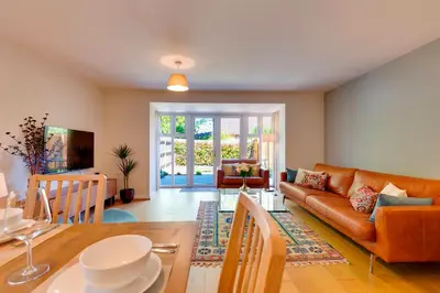 a living room with a couch and a table at Stylish luxury on edge of Cambridge Free Parking Pass the Keys in Cottenham