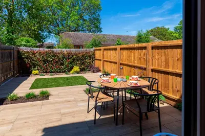 a patio with a table and chairs and a fence at Stylish luxury on edge of Cambridge Free Parking Pass the Keys in Cottenham