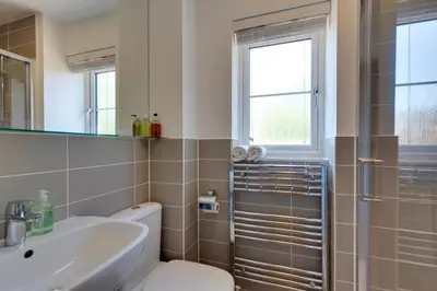 a bathroom with a toilet and a sink and a shower at Stylish luxury on edge of Cambridge Free Parking Pass the Keys in Cottenham