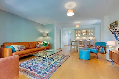 a living room with a couch and a table at Stylish luxury on edge of Cambridge Free Parking Pass the Keys in Cottenham