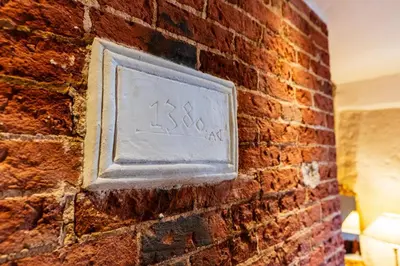 a brick wall with a plaque on it at Cosy & charming medieval 'Bumble Cottage' in Kersey