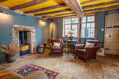 a living room with chairs and a fireplace at Cosy & charming medieval 'Bumble Cottage' in Kersey