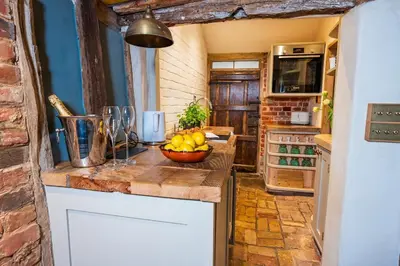 a kitchen with a bowl of fruit on a counter at Cosy & charming medieval 'Bumble Cottage' in Kersey