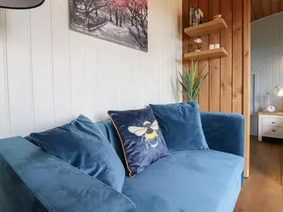 a blue couch with a flower pillow on it at Barn Owl in Cambridge