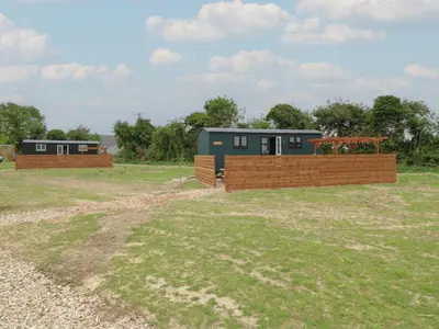 a house with a fence in a field at Barn Owl in Cambridge