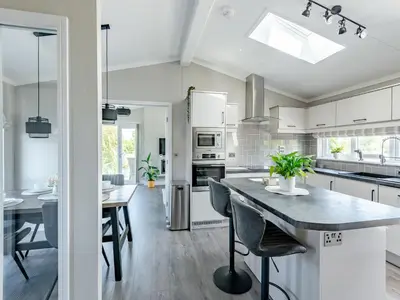 a kitchen with white cabinets and a dining table at Sunnyfields in Cambridge