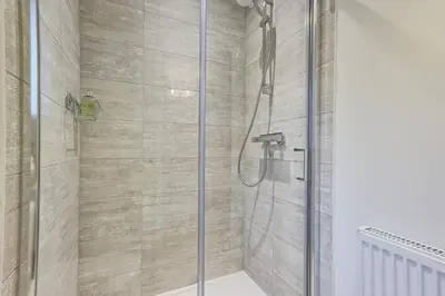 a shower with a glass door in a bathroom at Luxury and cosy 2 bed entire house in Essex 20 mins from beach in Colchester