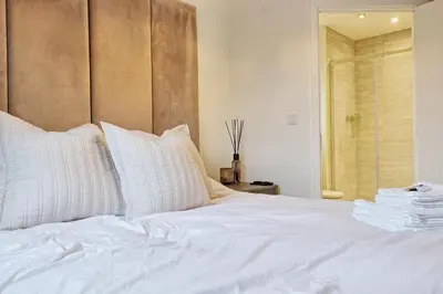 a white bed with white pillows in a bedroom at Luxury and cosy 2 bed entire house in Essex 20 mins from beach in Colchester