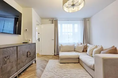 a living room with a white couch and a tv at Luxury and cosy 2 bed entire house in Essex 20 mins from beach in Colchester