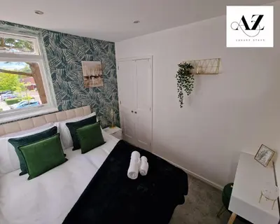 a bedroom with a bed with green and white pillows at Mansion House Apartment,WIFI,FAMILY,CONTRACTORS in Newmarket