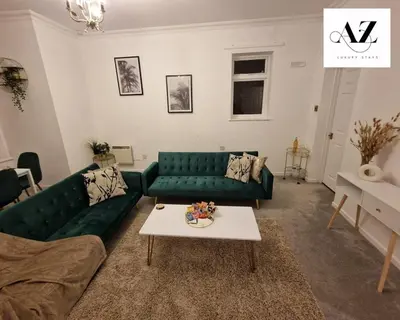 a living room with a green couch and a table at Mansion House Apartment,WIFI,FAMILY,CONTRACTORS in Newmarket