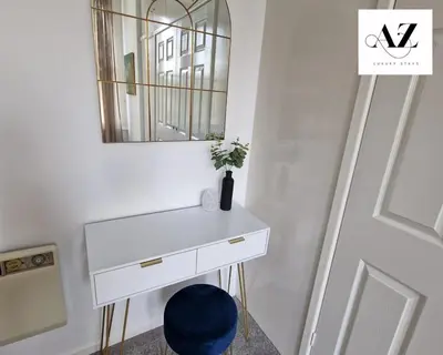 a white dressing table with a mirror and a blue stool at Mansion House Apartment,WIFI,FAMILY,CONTRACTORS in Newmarket