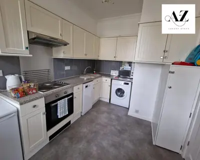a kitchen with white cabinets and a washer and dryer at Mansion House Apartment,WIFI,FAMILY,CONTRACTORS in Newmarket