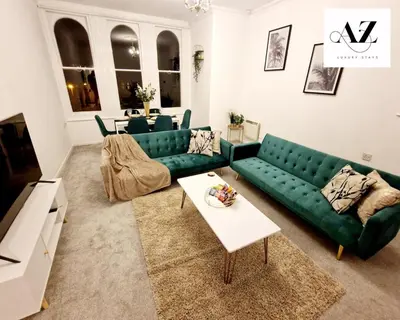 a living room with a green couch and a table at Mansion House Apartment,WIFI,FAMILY,CONTRACTORS in Newmarket