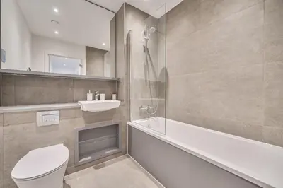 a bathroom with a toilet and a tub and a sink at Peaceful and stylish apartment near Cambridge with parking in CBG