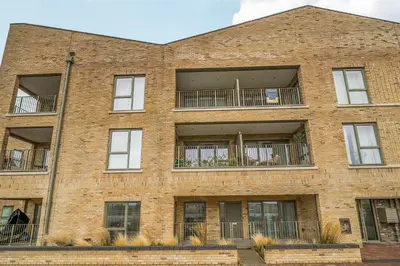 an apartment building with windows and balconies at Peaceful and stylish apartment near Cambridge with parking in CBG