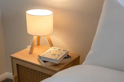 a lamp on a night stand next to a bed at 15 Mins to Sizewell C - Driveway Parking - Contractor Friendly - 2 Bedroom in Saxmundham