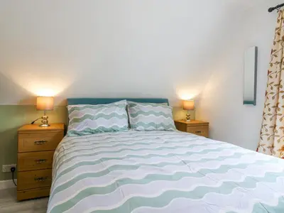 a bedroom with a large bed with two night stands at Kingfisher in Ely