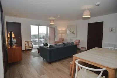 a living room with a couch and a table at Seaview City Lodge , 2- bedroom flat with Parking in Southend-on-Sea
