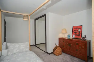a bedroom with a bed and a dresser and a mirror at Seaview City Lodge , 2- bedroom flat with Parking in Southend-on-Sea