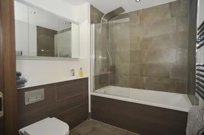 a bathroom with a tub and a toilet and a shower at Seaview City Lodge , 2- bedroom flat with Parking in Southend-on-Sea